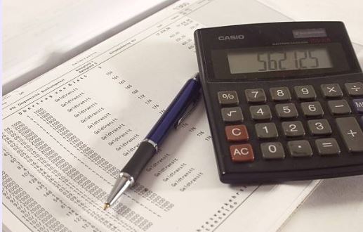 Calculator, pen, and closing documents representing typical seller closing costs in Florida.