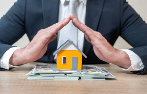 Small model home protected by a business professional’s hands, symbolizing home warranty coverage in Citrus County.