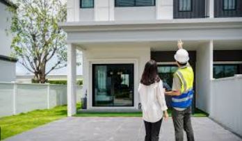 Home inspection shown with an inspector pointing out exterior details to a buyer during a walk-through