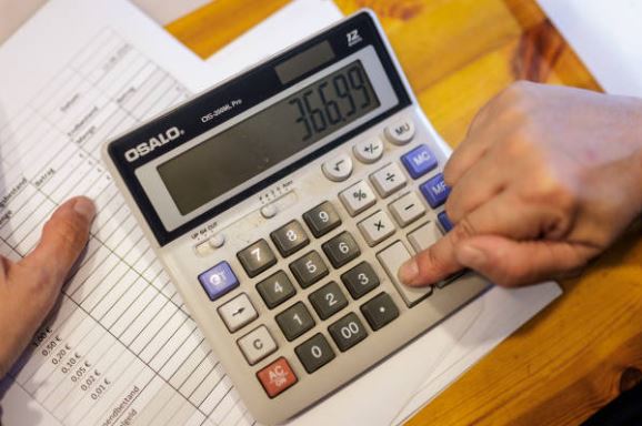 Person calculating buyer concessions and seller costs on a calculator before listing a home in Citrus County
